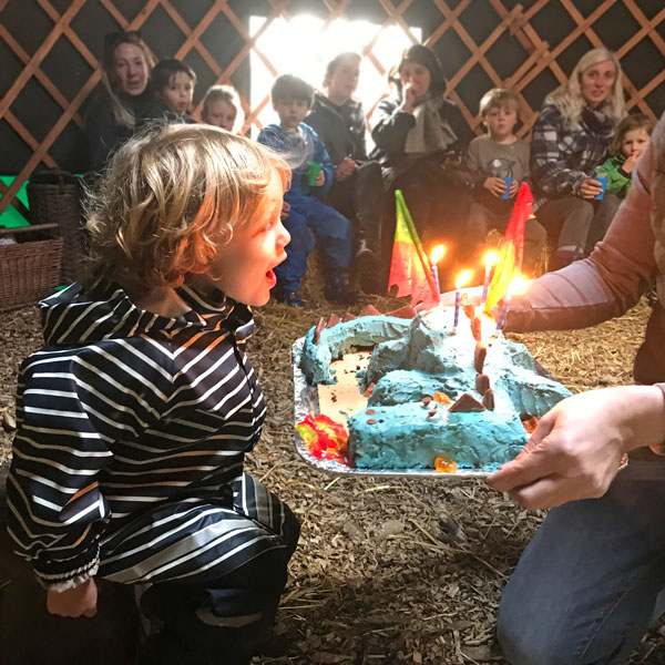 boy blowing out birthday cake candles