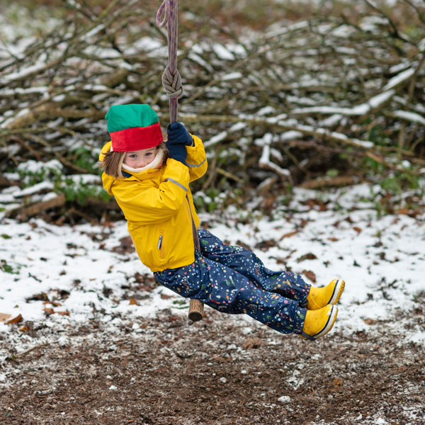 Girl in snow on a rope swing