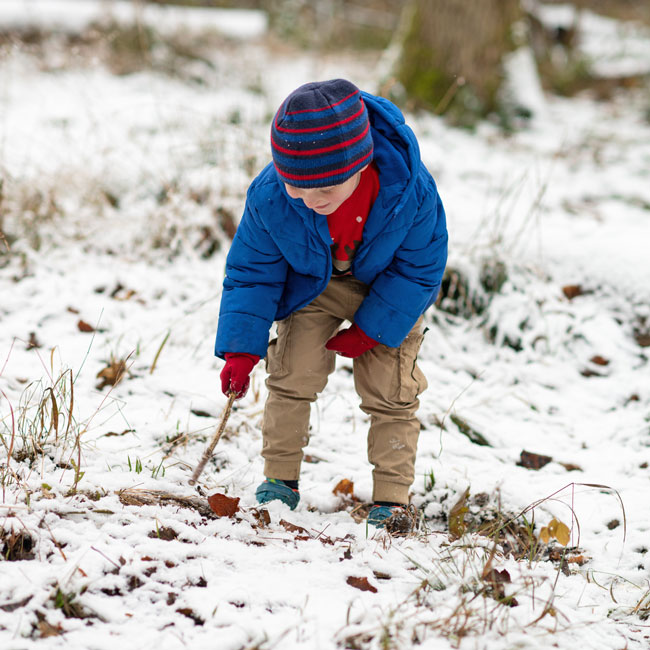 Boy with stick in the snow